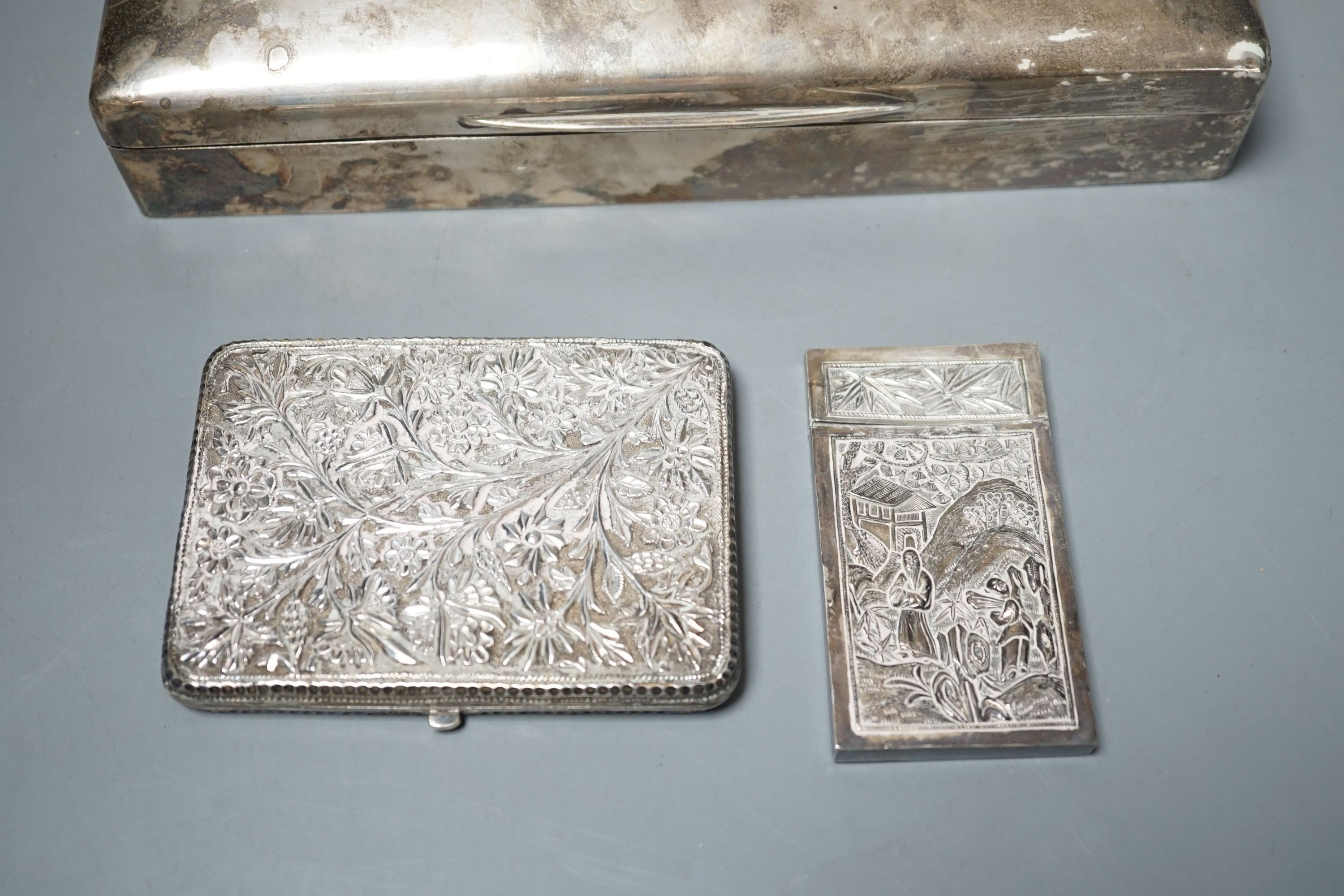 A George V silver mounted cigarette box, London, 1913, 23cm, a Chinese? white metal card case(a.f.) and an Indian? white metal cigarette case.